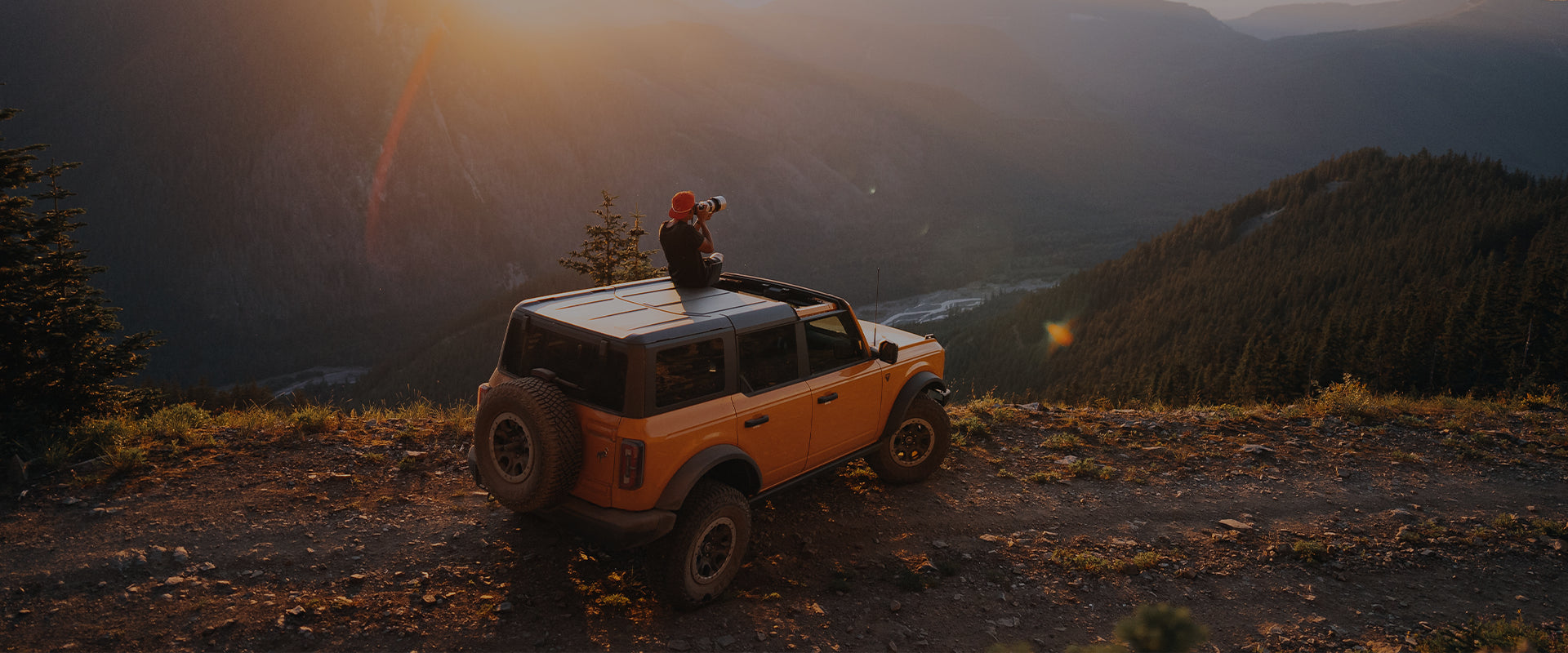 SeaBear Ambassador Mikey Holmquist sitting on a Ford Bronco atop a mountain overlooking a Pacific Northwest landscape | SeaBear Smokehouse