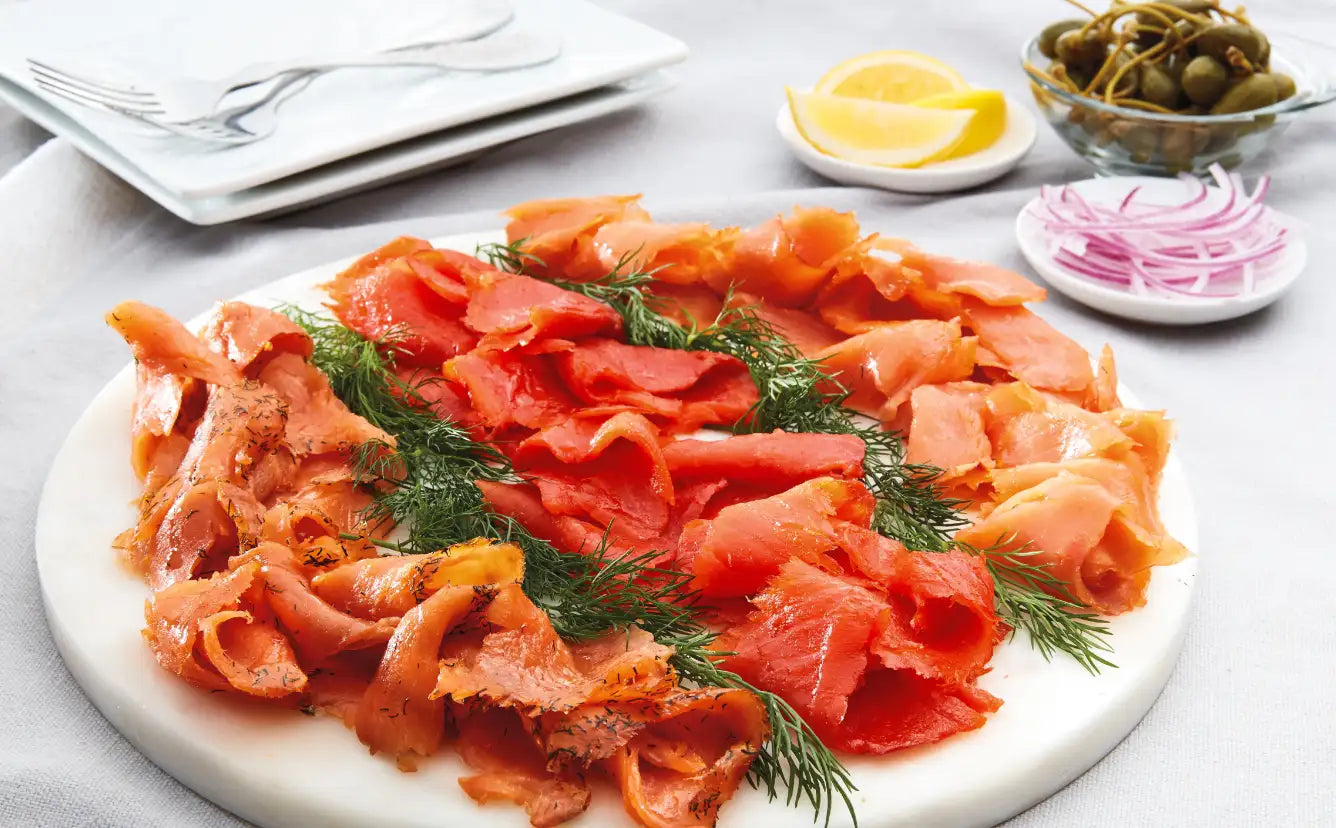 SeaBear Smokehouse | Smoked Coho Salmon Lox, Sockeye Salmon Lox and Coho Gravlax with a dill garnish.