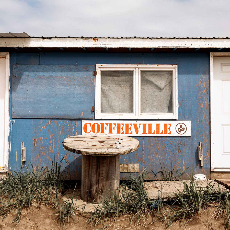 A blue outbuilding with a sign that says "Coffeeville" in Coffee Point, Alaska | Fresh & Wild | SeaBear Smokehouse