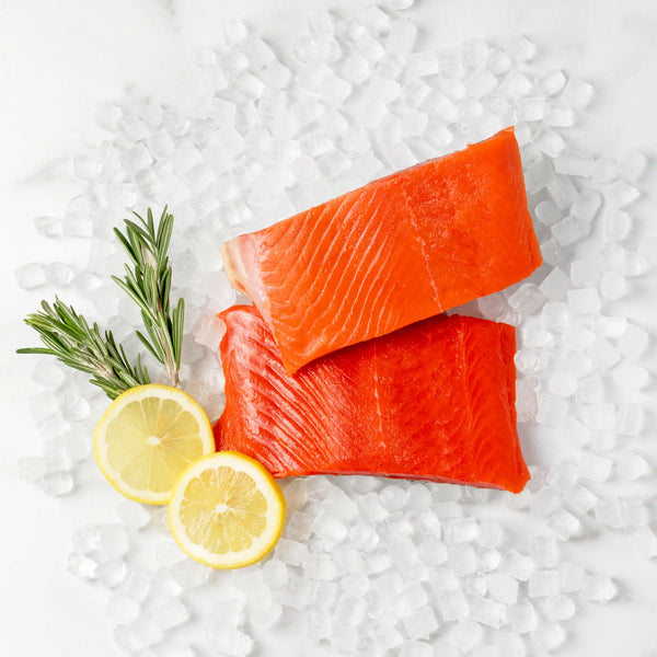 SeaBear | Two wild sockeye salmon dinner fillets with a lemon garnish.