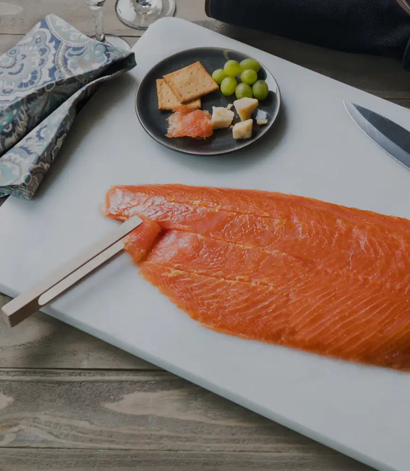 tongs holding up slice of lox