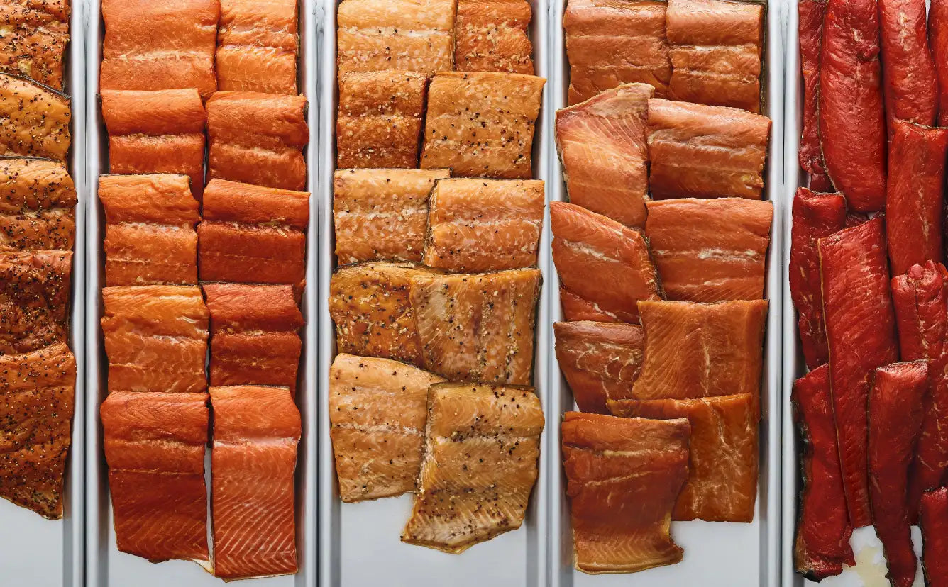 SeaBear Smokehouse | Hot smoked salmon fillets, layered on metal trays.